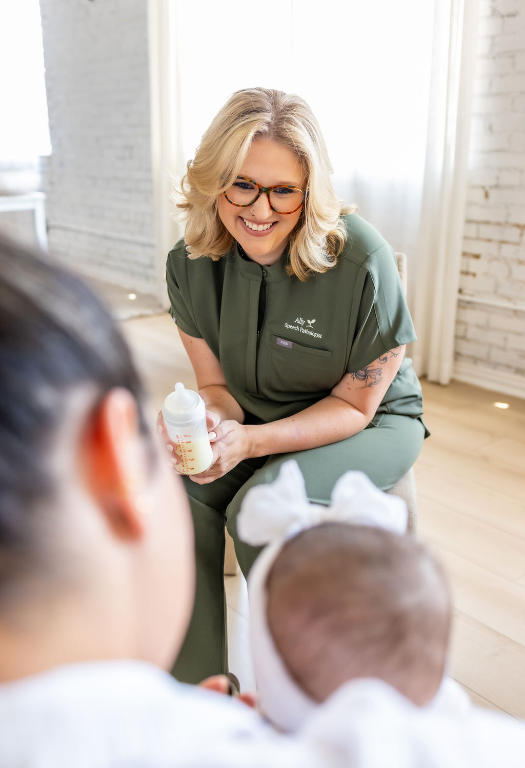 Ally Gore holding a baby bottle while talking with a family