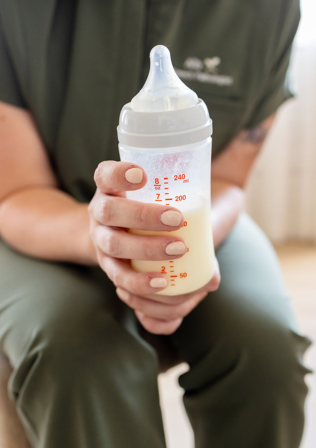 Close-up of a clinician holding a baby bottle