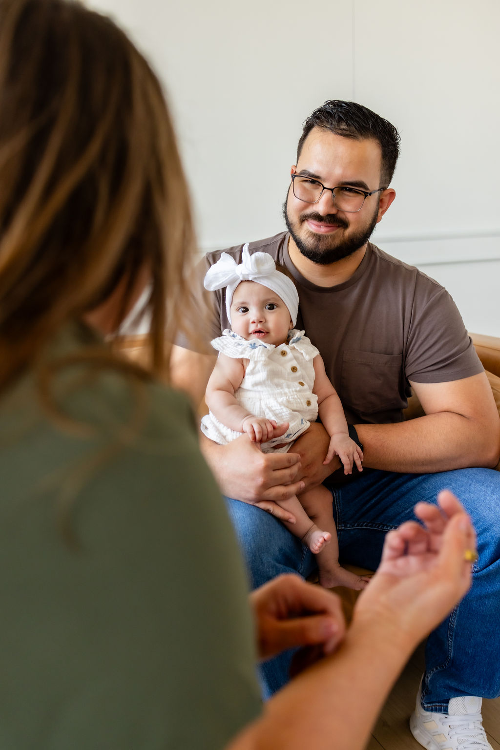 A father holding an infant while talking with a clinician