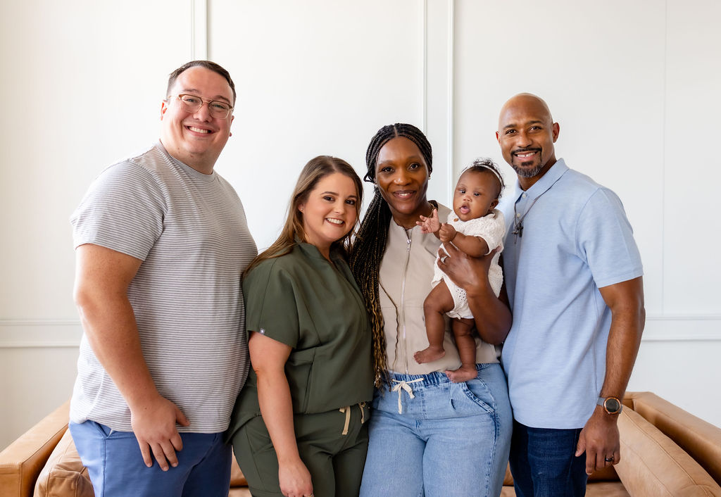 A family with an infant posing with Brittany Shockley and another adult