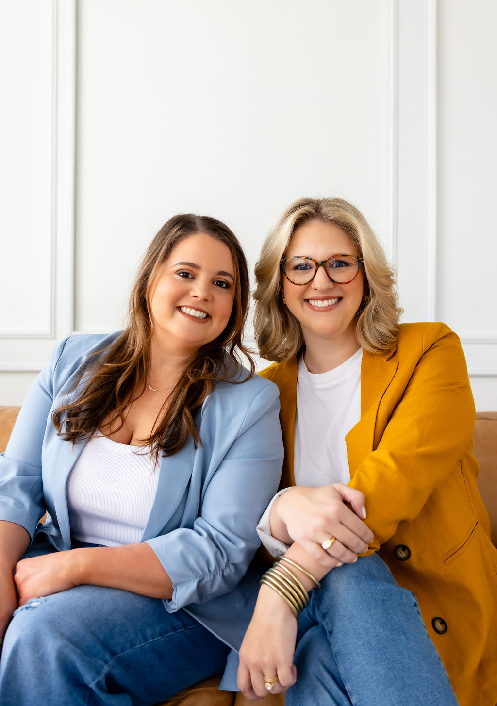 Co-founders Brittany Shockley and Ally Gore seated together on a sofa